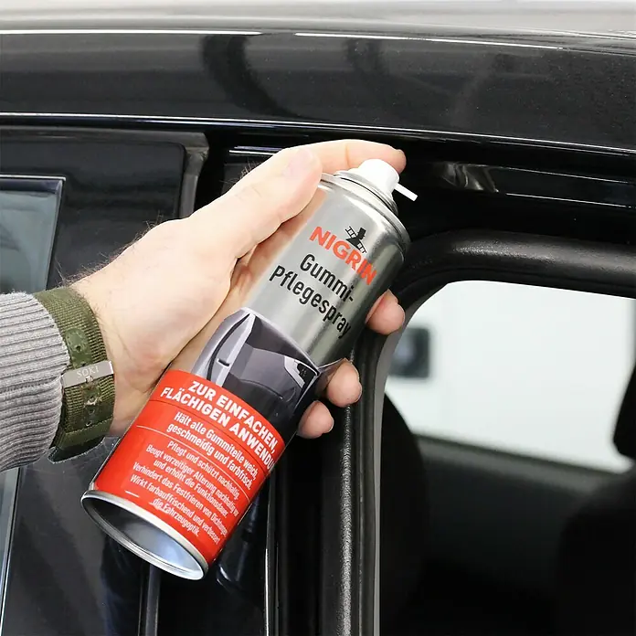 Nigrin Gummi-Pflegespray - 300 ml - Detailaufnahme einer Dose Nigrin Gummi-Pflegespray zur Gummipflege am Auto, gehalten in der Hand.