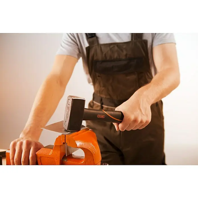 Picard Fäustel BlackTec® - Gewicht Kopf: 1.250 g, Spezialstahl - Ein Handwerker bearbeitet Metall mit einem Hammer in einem Schraubstock, wobei die Marke Picard am Hammergriff sichtbar ist.