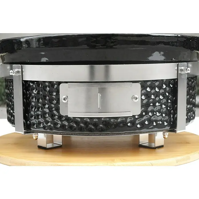 Kingstone Holzkohlegrill Kamado Tischgrill - Durchmesser Grillfläche: 29,5 cm, Schwarz - Nahaufnahme eines schwarzen Kamado-Grills mit Metallbeschlägen auf einem Holztisch, der die Details des Grills hervorhebt.