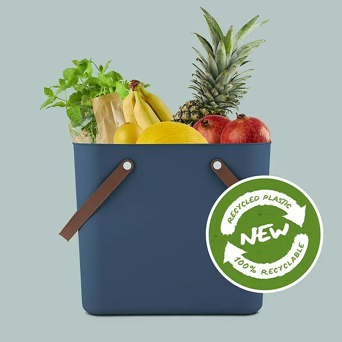 Rotho Albula Tasche Multibag Classic - 25 l, Dunkelblau, Kunststoff - Blauer Einkaufskorb aus recyceltem Kunststoff, gefüllt mit frischem Obst und Kräutern, beworben mit einem "New 100% Recyclable"-Siegel.