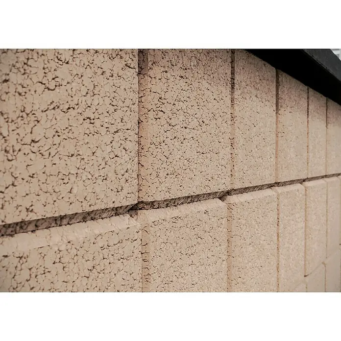 Christoph Gartenmauer Ambienta - 40 x 20 x 20 cm, Mediterran, Beton - Nahaufnahme einer Fassade aus rosafarbenen Betonsteinen mit einer rauen, unebenen Textur und dunklen Akzenten oben, die ein robustes, modernes Aussehen verleihen.
