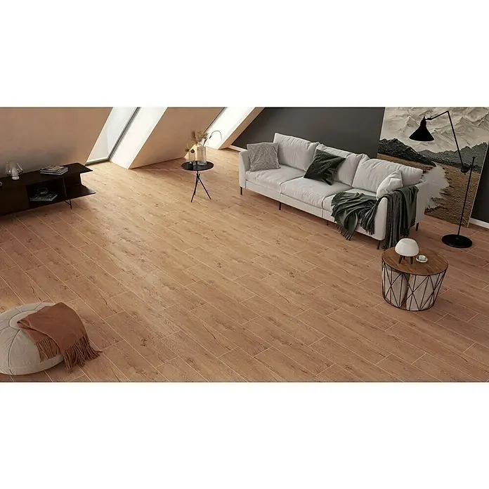 Atlas Concorde Solution Fable Feinsteinzeugfliese Honey - 22,5 x 90 cm, Braun, Matt - Das Bild zeigt ein modern eingerichtetes Wohnzimmer mit einem hellen Sofa und Holzbodenfliesen, die dem Raum Wärme verleihen.