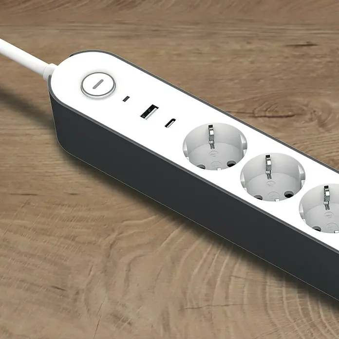 UniTEC Steckdosenleiste Greenline - 4-fach, Weiß/anthrazit, Kabellänge: 1,8 m, Mit Schalter - Nahaufnahme eines grauen Stromverteilers mit weißen Steckdosen, USB-Anschlüssen und einem weißen Kabel auf einem Holztisch.