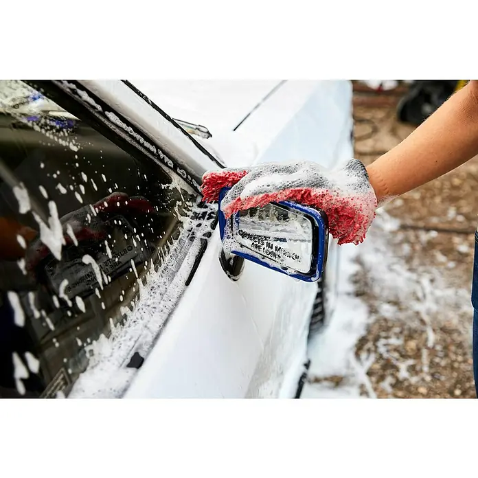 Nigrin Performance Finger- & Waschhandschuh - Rot, Mikrofaser - Ein Waschhandschuh mit roter Krempe reinigt einen Auto-Seitenspiegel während einer Autowäsche.