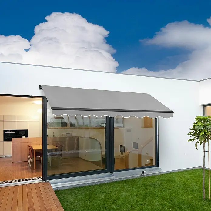 SmartSun Toldo de brazos extensibles Dark Easy Lite - Gris piedra, Ancho: 3 m, Caída: 2 m - Un toldo gris protege una puerta de patio del sol, proporcionando sombra en el patio. La elegante solución de sombreado realza la casa.