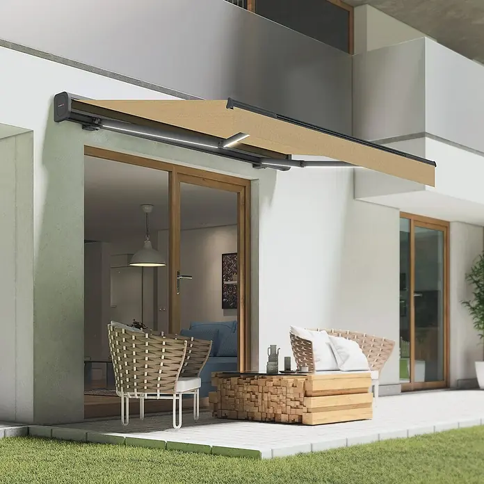 SmartSun Toldo de brazos extensibles LED solar Dark Vivant - Beige, Ancho: 3 m, Caída: 2 m - Un elegante toldo proporciona sombra en una terraza moderna con muebles elegantes, creando un ambiente agradable.