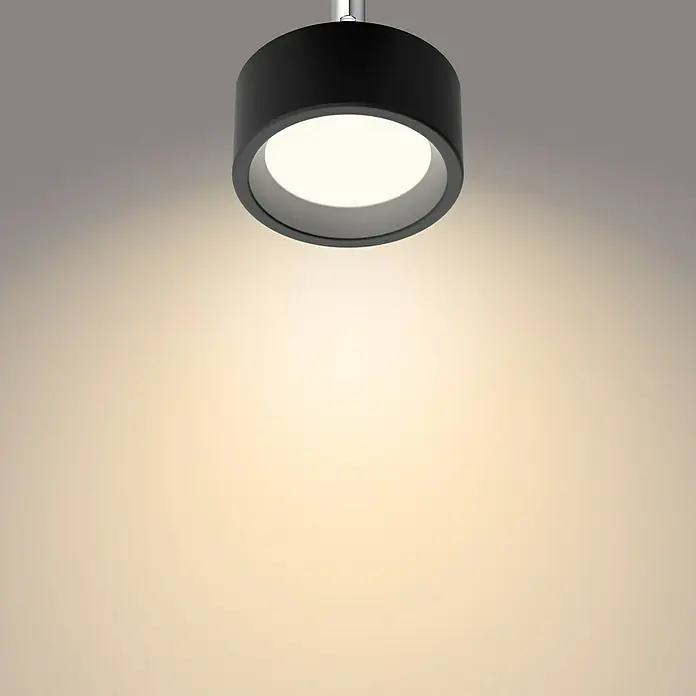 Philips Regleta LED Bracia - 5,5 W, L x An x Al: 9 x 9 x 12,5 cm, Negro, Blanco cálido, 1 ud. - Primer plano de una lámpara de techo moderna negra, con una luz redonda y brillante, que crea un ambiente cálido.