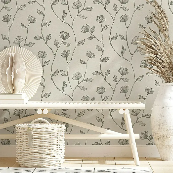 Marburg GZSZ Vliestapete Blumenranke - Beige/Gold, Floral, 10,05 x 0,53 m - Ein eleganter Raum mit floral gemusterter Tapete, einer weißen Bank, einer dekorativen Schale und einer Vase mit Pampasgras für ein harmonisches Ambiente.