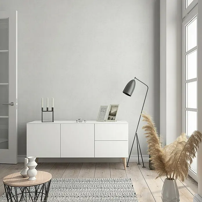Marburg GZSZ Vliestapete - Helles Weißgrau, Uni, 10,05 x 0,53 m - Eine moderne Wohnzimmerszene mit einem weißen Sideboard, das als stilvolle Ablagefläche dient. Die minimalistische Ästhetik wird durch Dekoelemente betont.
