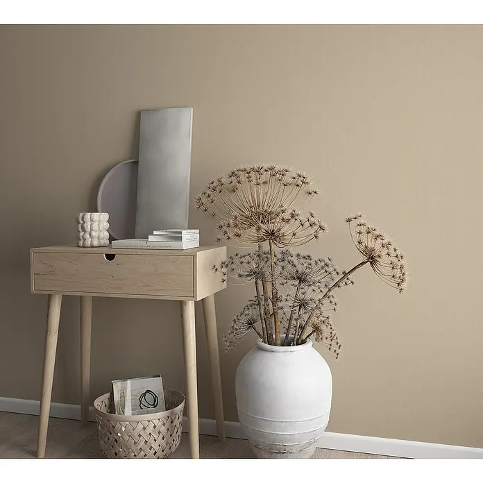 Marburg GZSZ Vliestapete - Beige, Uni, 10,05 x 0,53 m - Ein stilvoller Beistelltisch aus hellem Holz mit dekorativen Objekten und einer Vase mit getrockneten Blumen, die eine gemütliche Atmosphäre schaffen.