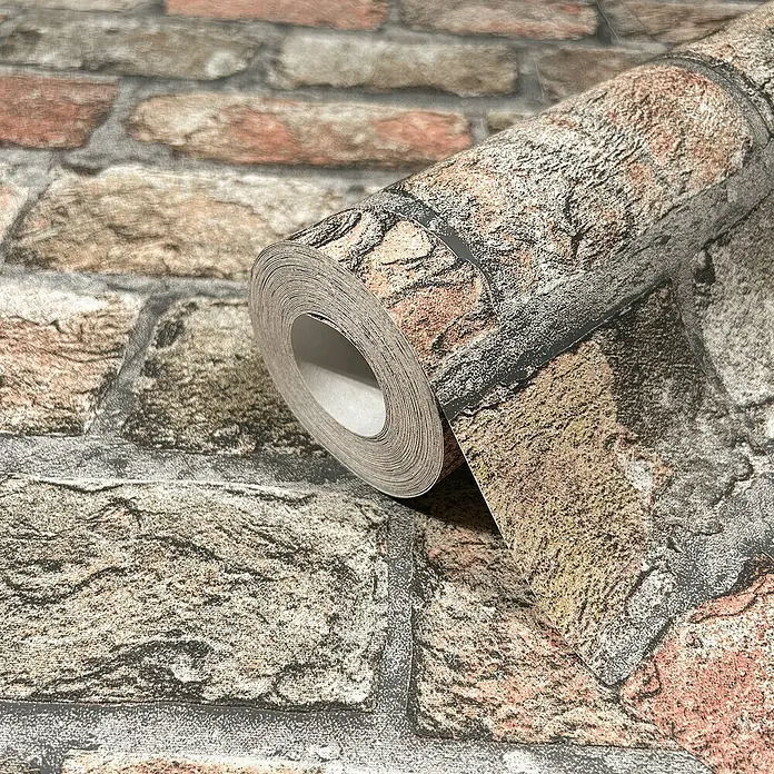 Marburg GZSZ Vliestapete Steinwand - Terra, Steinoptik, 10,05 x 0,53 m - Nahaufnahme einer Rolle Ziegelstein-Tapete, die ein realistisches Mauerwerkdesign mit verschiedenen Farbnuancen zeigt.