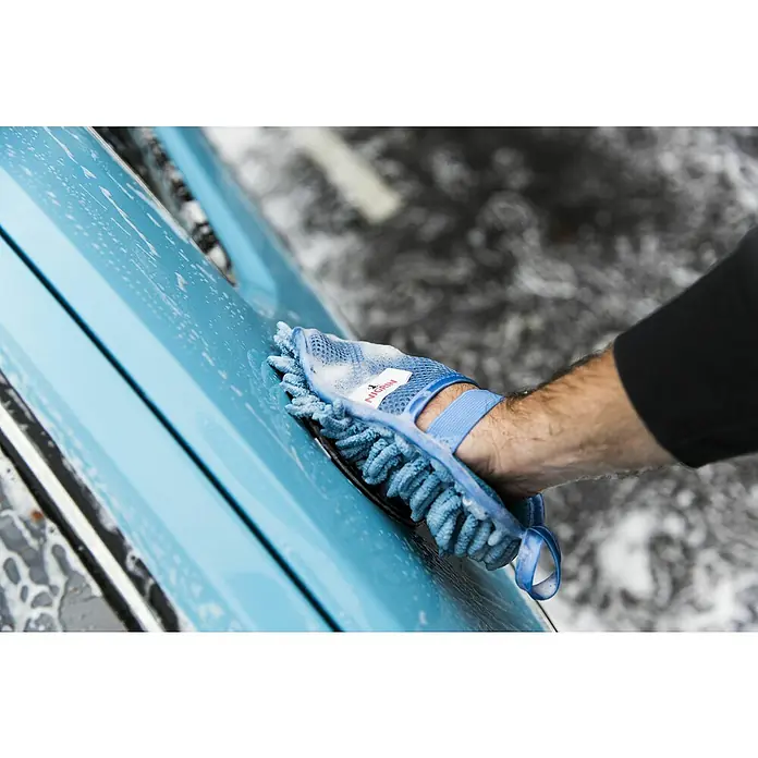 Nigrin Performance Mikrofaser-Waschhandschuh - 22 x 17 cm - Nahaufnahme eines blauen Autos, das mit einem blauen Nigrin Waschhandschuh gereinigt wird, Schaum bedeckt die Oberfläche.