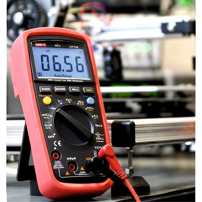 Multímetro digital UT139A - Rango de medición tensión alterna: 2 V - 600 V - Multímetro digital rojo y negro (UNI-T UT139) mostrando 06.56 kΩ con puntas de prueba conectadas en laboratorio.