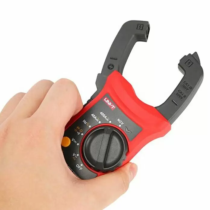 Multímetro abrazadera digital - Control de continuidad - Un amperímetro de pinza UNI-T rojo y negro, sostenido en una mano, con un selector giratorio para corriente, voltaje y frecuencia.