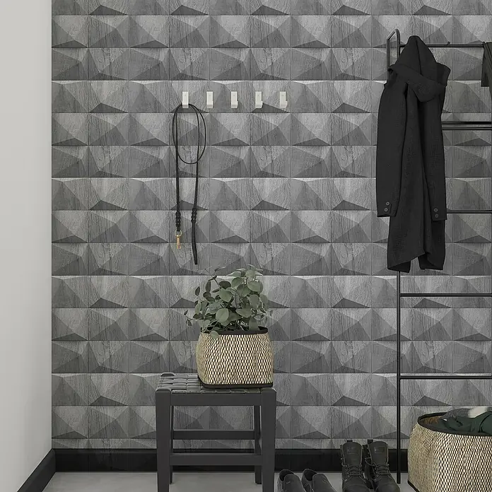 Marburg GZSZ Vliestapete Holzwand - Hellgrau, 3D-Optik, 10,05 x 0,53 m - Wohnungsflur mit einer grauen 3D-Akzentwand, schwarzem Hocker, gewebtem Korb und einem schwarzen Mantel, der an einer Kleiderstange hängt.