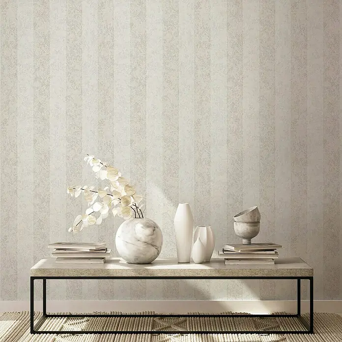 Marburg GZSZ Vliestapete - Weiß, Streifen, 10,05 x 0,53 m - Elegantes Interieur mit einer Marmorvase, weißen Vasen und Büchern auf einem Couchtisch, vor einer stilvollen gestreiften Tapete.