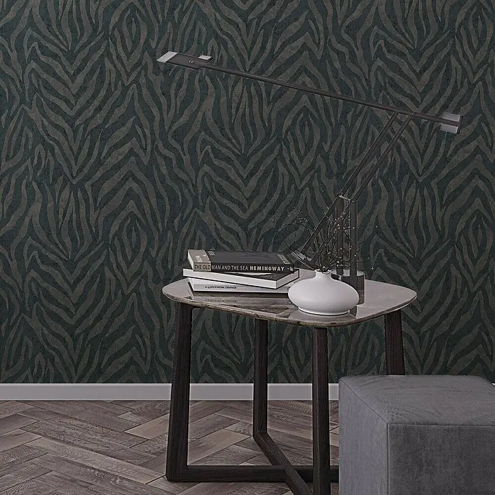Marburg GZSZ Vliestapete Moderner Zebralook - Schwarz/Braun, Tieroptik, 10,05 x 0,53 m - Dieses Bild zeigt einen eleganten Beistelltisch mit Büchern, einer Lampe und einem kleinen Dekorationsobjekt vor einer gemusterten Tapete.
