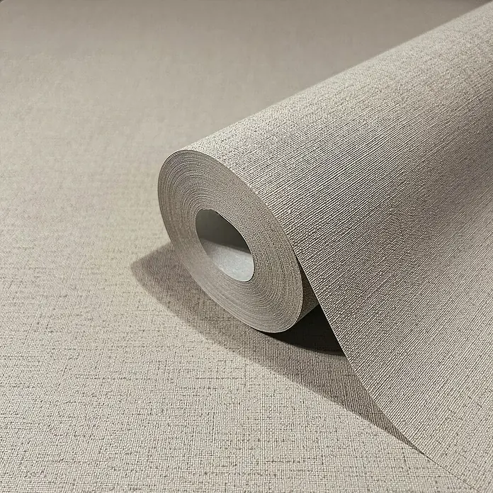Marburg GZSZ Vliestapete - Braun, Uni, 10,05 x 0,53 m - Nahaufnahme einer Rolle beiger Textiltapete, die eine dezente und elegante Wandgestaltung verspricht.