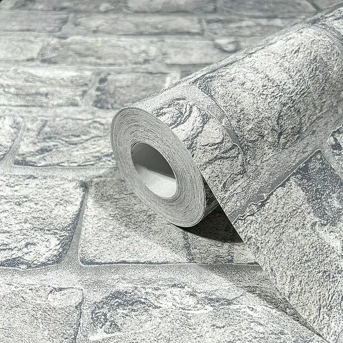 Marburg GZSZ Vliestapete Steinwand - Steingrau, Steinoptik, 10,05 x 0,53 m - Nahaufnahme einer Rolle grauer Ziegel Tapete, die eine realistische Steinmauer Optik erzeugt und jedem Raum Tiefe verleiht.