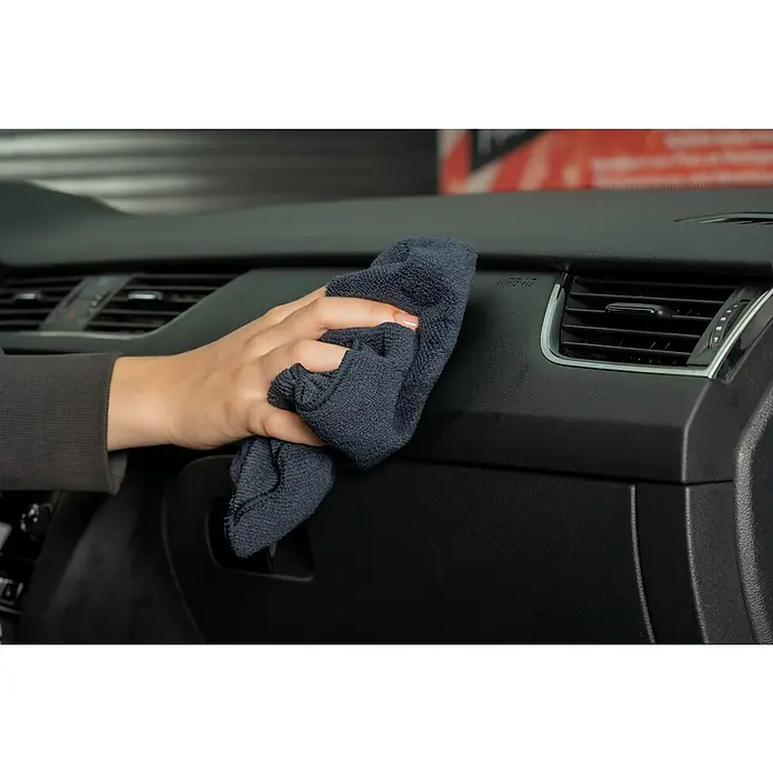Nigrin Performance Cockpit-Lotion - 300 ml - Ein Mikrofasertuch reinigt das Armaturenbrett eines Autos. Die Verwendung eines Mikrofasertuchs ist eine schonende und effektive Methode, um Staub und Schmutz zu entfernen.