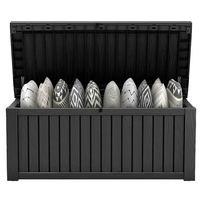 Keter Gartenbox Rockwood - 570 l, Kunststoff - Eine graue Gartenbox mit geöffnetem Deckel, gefüllt mit dekorativen Kissen in verschiedenen Mustern. Die Box ist aus Holz und bietet Stauraum für den Außenbereich.