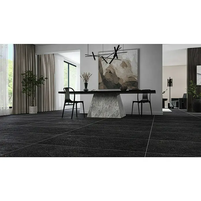 Feinsteinzeugfliese Lavagna Nera - 60 x 120 cm, Schwarz, Matt - Elegantes Interieur mit schwarzen Bodenfliesen, einem Esstisch mit Marmorbasis und moderner Kunst an der Wand, die ein stilvolles Ambiente schaffen.