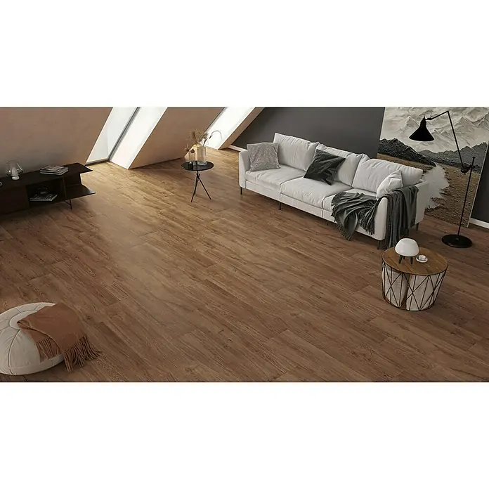 Harmonie by Palazzo Feinsteinzeugfliese - 30 x 120 cm, Eiche Dunkel, Matt - Dieses Bild zeigt ein Wohnzimmer mit einem hellen Sofa und Holzboden. Die braune Holzstruktur des Bodens verleiht dem Raum Wärme.