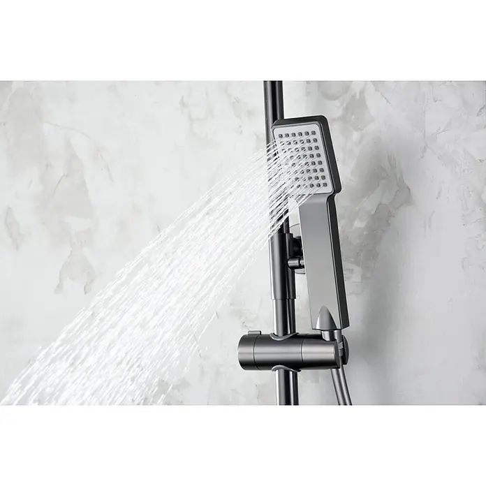 Imex Art Sistema de ducha - Grifo termostático, Black gun metal - Primer plano de un moderno accesorio de ducha gris rociando agua, sobre un fondo claro marmoleado.