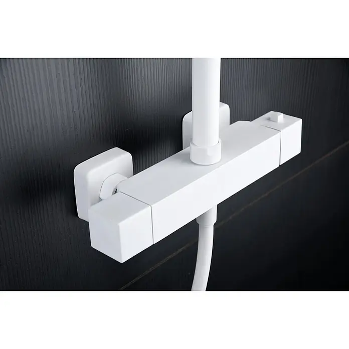 Imex Art Sistema de ducha - Grifo termostático, Blanco - Primer plano de un conjunto de grifo de ducha blanco con un diseño rectangular, montado en una pared oscura y texturizada. La fijación es moderna y minimalista.