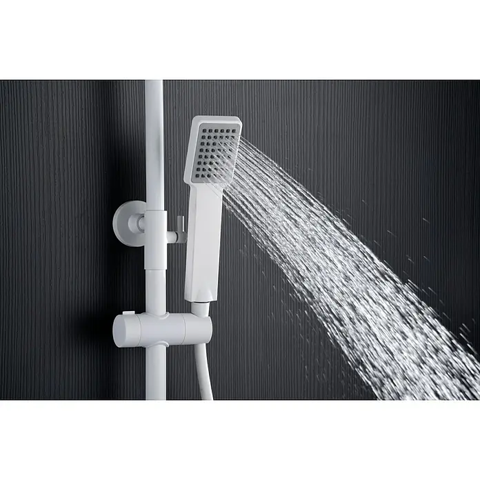 Imex Art Sistema de ducha - Grifo termostático, Blanco - Primer plano de un cabezal de ducha blanco con agua corriente sobre una pared oscura.