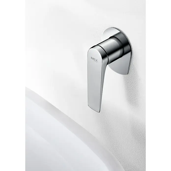 Imex Delos Grifo de lavabo - Cromo - Primer plano de un grifo de agua cromado IMEX montado en una pared blanca.
