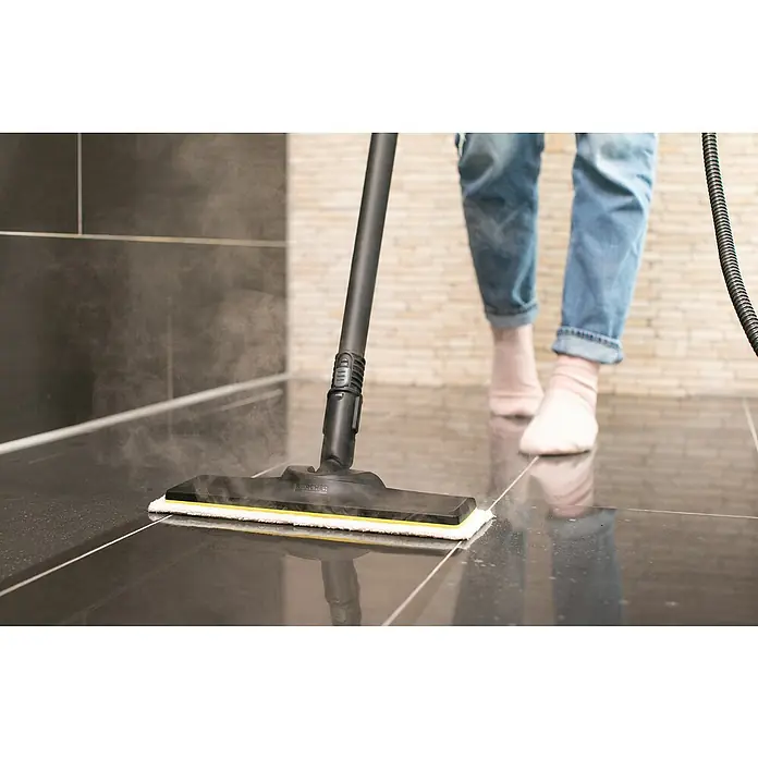 Kärcher Dampfreiniger SC 4 EasyFix - 2.000 W, Behältervolumen: 0,8 l - Eine Person verwendet einen Kärcher Dampfreiniger zum Reinigen von dunklen Fliesen, wobei Dampf freigesetzt wird, um eine effektive Reinigung zu gewährleisten.
