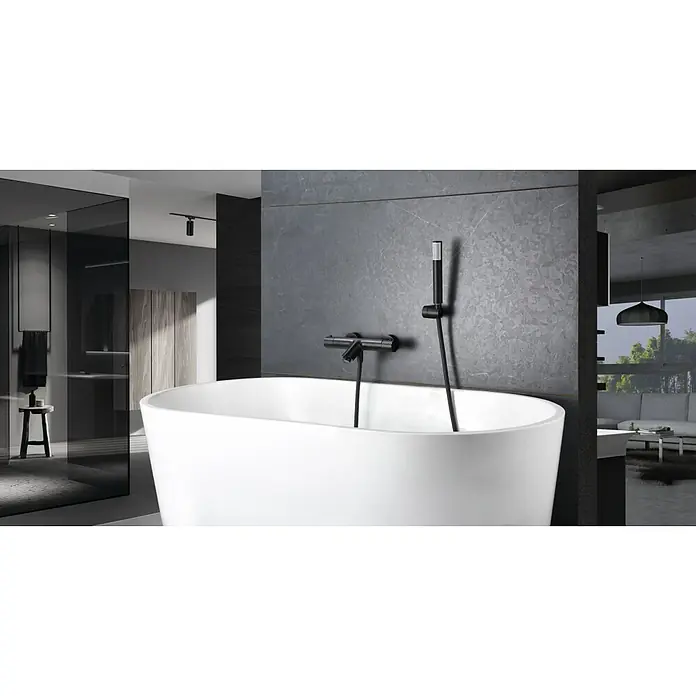 Imex Génova Grifo monomando de bañera - Negro, Mate - Bañera moderna con un elegante grifo negro sobre una pared de acento gris. El diseño del baño es minimalista y elegante.