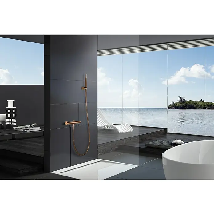 Imex Génova Grifo con termostato - Ancho: 29,5 cm, Oro rosa - Vista detallada de un elegante grifo de ducha color cobre sobre un fondo de azulejos oscuros en un baño de lujo con vistas al océano.