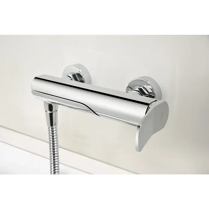 Imex Dinamarca Grifo monomando de bañera - Profundidad del grifo: 20,2 cm, Cromo, Brillante - Primer plano de un grifo de ducha cromado con manguera en una pared blanca, mostrando un diseño moderno y elegante.