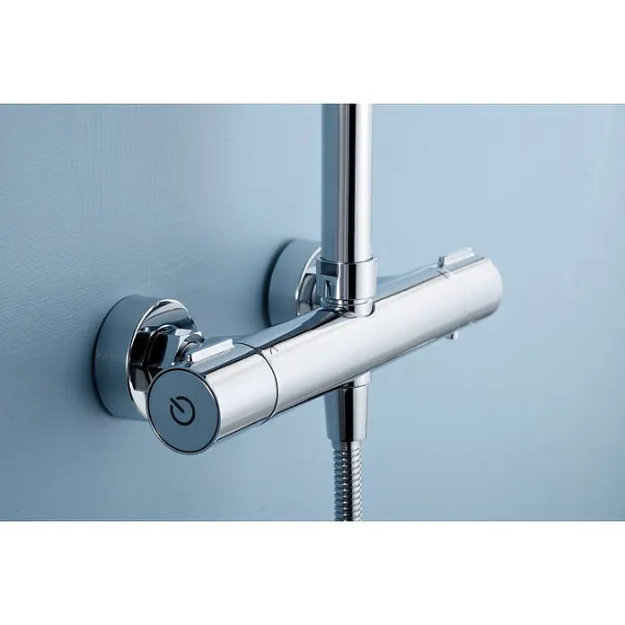 Imex Sistema de ducha Eco-Kent - Con grifo termostático, Cromo - Primer plano de una elegante válvula de ducha termostática cromada montada en una pared azul claro, que muestra un diseño moderno y funcionalidad.