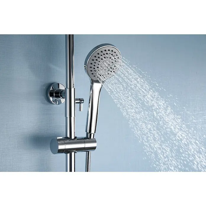 Imex Sistema de ducha Eco-Kent - Con grifo termostático, Cromo - Primer plano de un cabezal de ducha plateado que rocía agua, montado en un poste contra una pared azul.