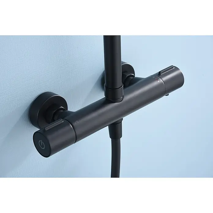 Imex Sistema de ducha Eco-Kent - Con grifo termostático, Negro - Primer plano de un grifo de ducha negro sobre una pared celeste, mostrando un diseño moderno y funcionalidad.