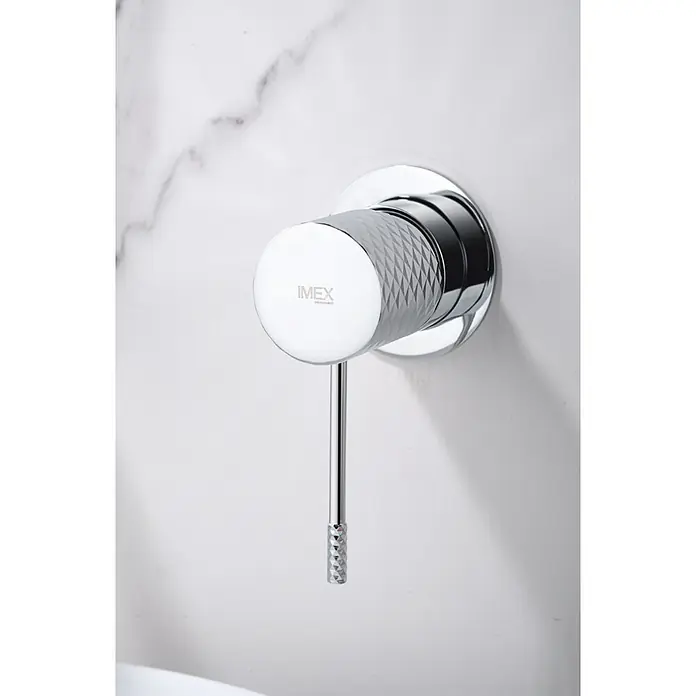 Imex Génova Grifo de lavabo empotrado - Cromo - Primer plano de un grifo IMEX con palanca sobre una pared de mármol blanco, destacando un diseño de baño elegante y moderno.