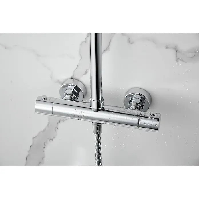 Imex Nápoles Sistema de ducha - Grifo termostático, Cromo - Primer plano de un brillante grifo de ducha cromado con gotas de agua sobre un fondo de mármol.