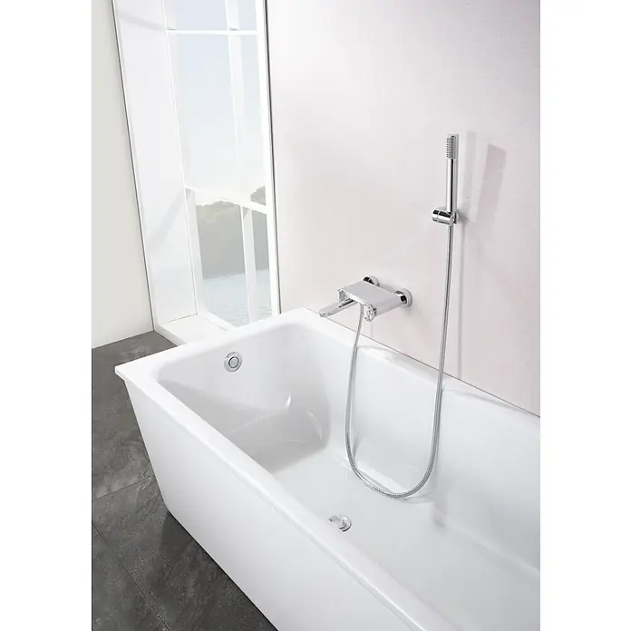 Imex Olimpo Grifo monomando de bañera - Cromo, Resplandeciente - Primer plano de una bañera blanca con grifo de cromo brillante y cabezal de ducha sobre un fondo luminoso.
