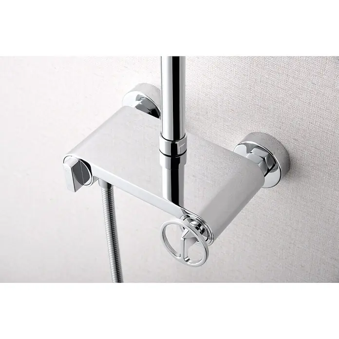 Imex Olimpo Sistema de ducha - Grifo monomando, Cromo - Primer plano de un grifo de ducha cromado brillante con estante y controles sobre un fondo claro y texturizado.