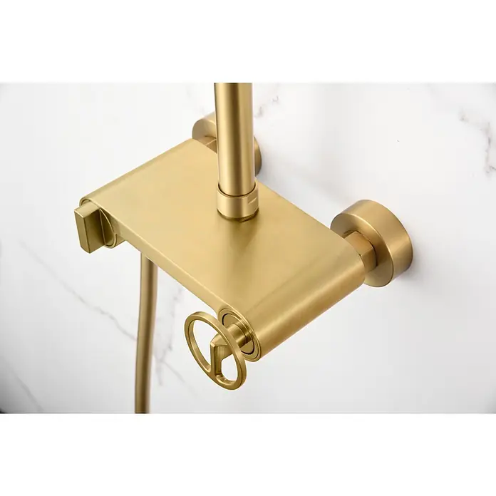 Imex Olimpo Sistema de ducha - Grifo monomando, Oro - Primer plano de un accesorio de ducha dorado con control de temperatura y estante contra una pared de mármol blanco.