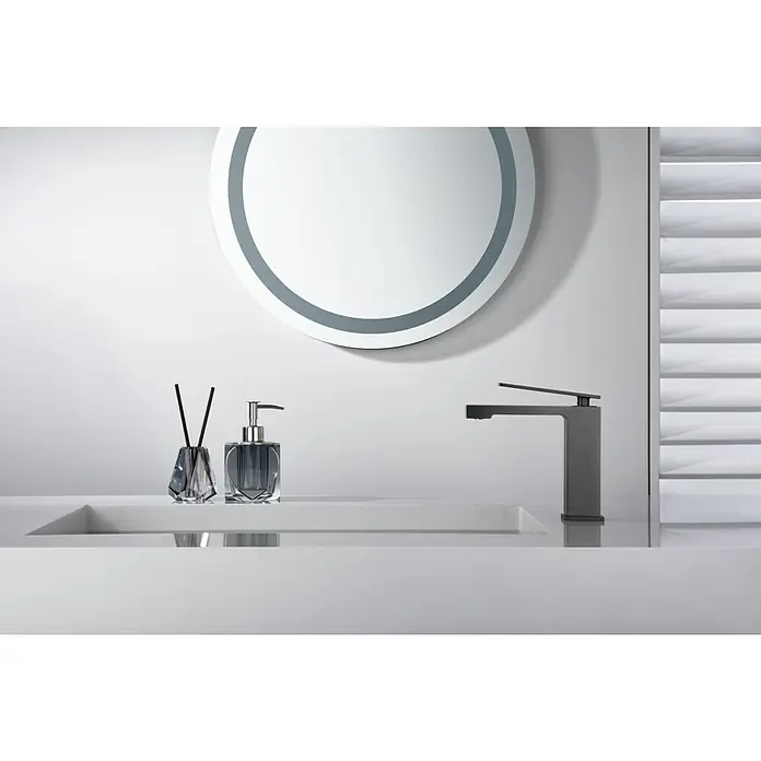 Imex Pisa Grifo de lavabo - Black gun - Elegante lavabo con grifo oscuro y estiloso, difusor de aroma y dispensador de jabón bajo un espejo redondo.