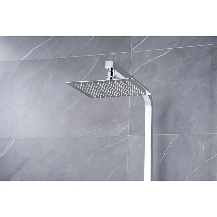 Imex Pisa Sistema de ducha - Grifo monomando, Cromo - Primer plano de un cabezal de ducha cuadrado con acabado cromado sobre un fondo de baldosas de mármol gris.
