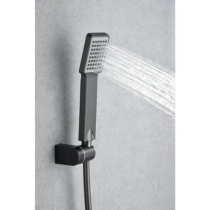 Imex Pisa Grifo de ducha - Black gun - Primer plano de un cabezal de ducha negro rociando agua, montado en una pared gris.