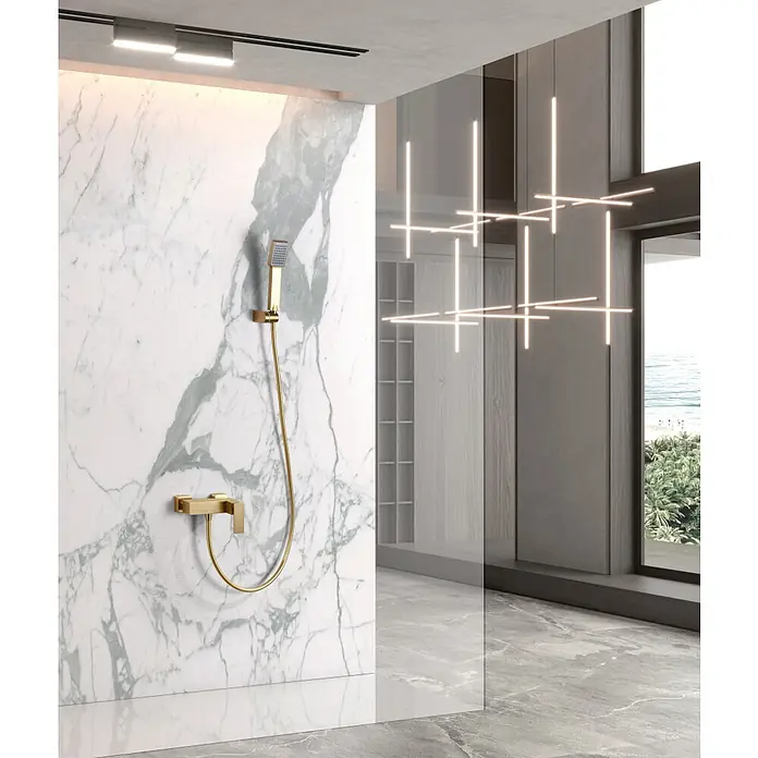 Imex Pisa Grifo de ducha - Oro - Elegante vista del baño con pared de mármol y accesorios de ducha dorados. El diseño moderno se complementa con iluminación elegante.