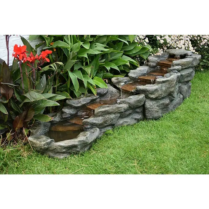 Ubbink AcquaArte Wasserspiel BREMBO - L x B x H: 212 x 58 x 51 cm - Dekorative Gartenbrunnenanlage mit Kaskaden aus Kunststein, umgeben von üppigen Pflanzen.