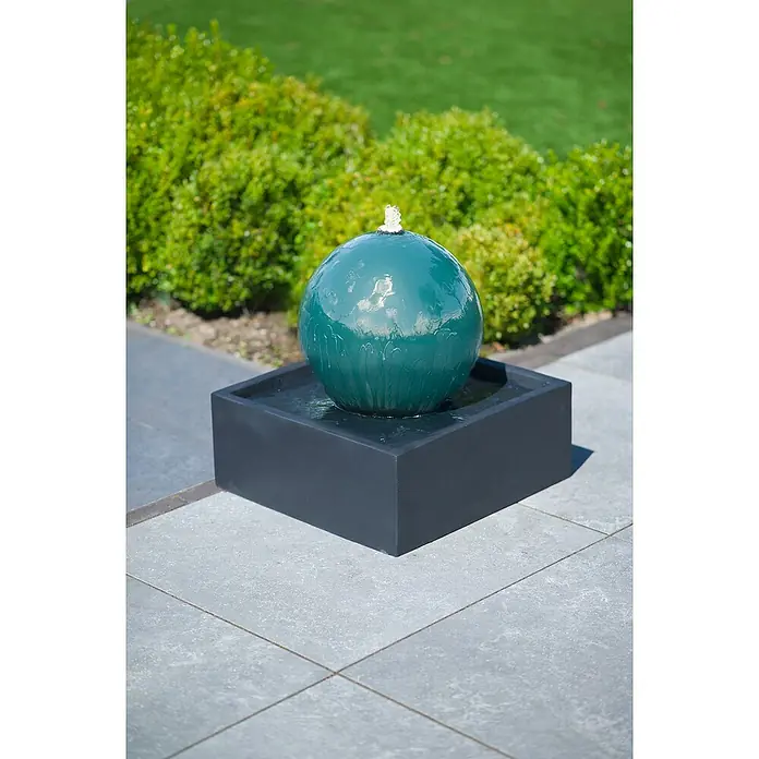Ubbink AcquaArte Standbrunnen Steni - 50 x 50 x 40 cm - Eine Nahaufnahme eines grünen Kugelbrunnen auf einem grauen Sockel, der Wasser sprudelt und eine beruhigende Atmosphäre erzeugt.