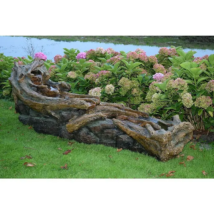Ubbink AcquaArte Standbrunnen Aviso - 199 x 52 x 70 cm - Ein dekorativer Gartenbrunnen in Form eines Baumstamms, umgeben von rosa Hortensien, bringt beruhigendes Wasserplätschern in Ihren Außenbereich.